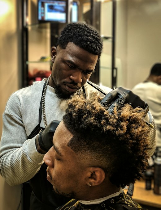 Barbeiro modelando cabelo crespo