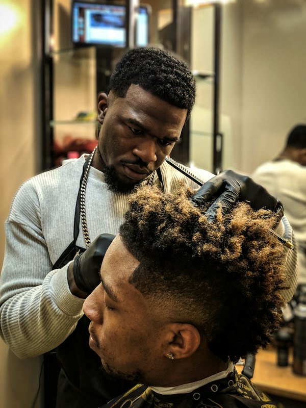 Barbeiro modelando cabelo crespo